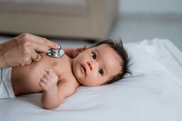 Pediatrician doctor examining baby girl at the hospital