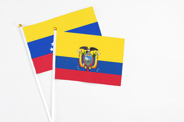 Obraz premium Ecuador and Venezuela stick flags on white background. High quality fabric, miniature national flag. Peaceful global concept.White floor for copy space.