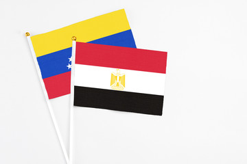 Egypt and Venezuela stick flags on white background. High quality fabric, miniature national flag. Peaceful global concept.White floor for copy space.