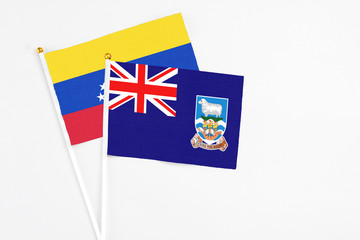 Fototapeta premium Falkland Islands and Venezuela stick flags on white background. High quality fabric, miniature national flag. Peaceful global concept.White floor for copy space.