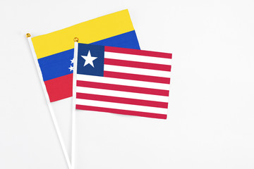 Liberia and Venezuela stick flags on white background. High quality fabric, miniature national flag. Peaceful global concept.White floor for copy space.