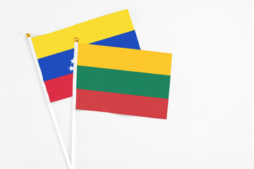 Lithuania and Venezuela stick flags on white background. High quality fabric, miniature national flag. Peaceful global concept.White floor for copy space.