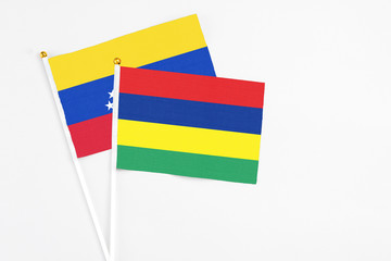 Mauritius and Venezuela stick flags on white background. High quality fabric, miniature national flag. Peaceful global concept.White floor for copy space.