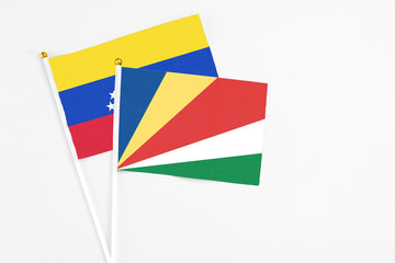 Seychelles and Venezuela stick flags on white background. High quality fabric, miniature national flag. Peaceful global concept.White floor for copy space.