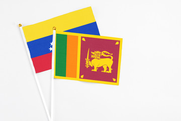 Sri Lanka and Venezuela stick flags on white background. High quality fabric, miniature national flag. Peaceful global concept.White floor for copy space.