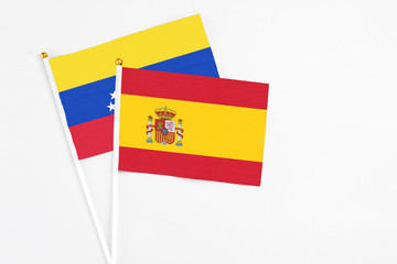 Spain and Venezuela stick flags on white background. High quality fabric, miniature national flag. Peaceful global concept.White floor for copy space.