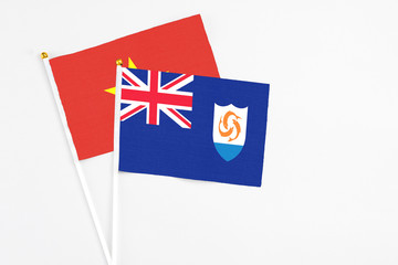 Anguilla and Vietnam stick flags on white background. High quality fabric, miniature national flag. Peaceful global concept.White floor for copy space.