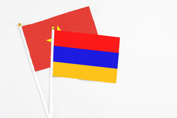 Armenia and Vietnam stick flags on white background. High quality fabric, miniature national flag. Peaceful global concept.White floor for copy space.