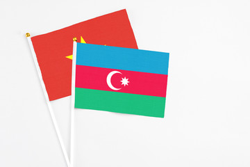 Azerbaijan and Vietnam stick flags on white background. High quality fabric, miniature national flag. Peaceful global concept.White floor for copy space.