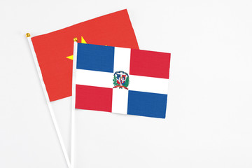 Dominican Republic and Vietnam stick flags on white background. High quality fabric, miniature national flag. Peaceful global concept.White floor for copy space.