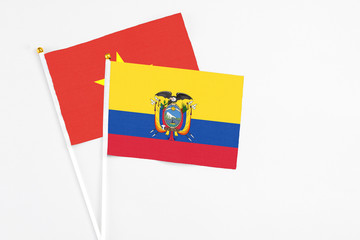 Ecuador and Vietnam stick flags on white background. High quality fabric, miniature national flag. Peaceful global concept.White floor for copy space.