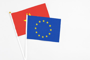 European Union and Vietnam stick flags on white background. High quality fabric, miniature national flag. Peaceful global concept.White floor for copy space.