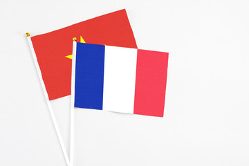 France and Vietnam stick flags on white background. High quality fabric, miniature national flag. Peaceful global concept.White floor for copy space.