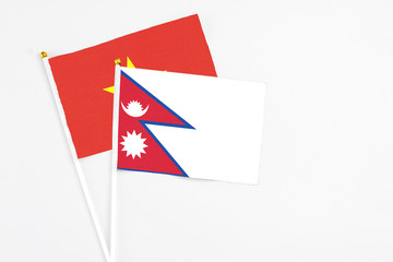 Nepal and Vietnam stick flags on white background. High quality fabric, miniature national flag. Peaceful global concept.White floor for copy space.