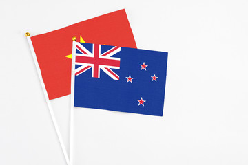 Fototapeta premium New Zealand and Vietnam stick flags on white background. High quality fabric, miniature national flag. Peaceful global concept.White floor for copy space.