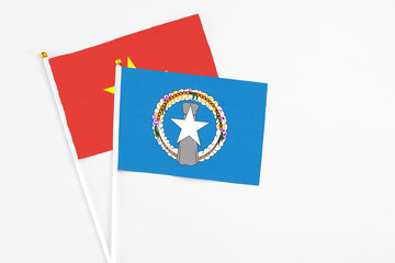 Northern Mariana Islands and Vietnam stick flags on white background. High quality fabric, miniature national flag. Peaceful global concept.White floor for copy space.