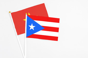 Puerto Rico and Vietnam stick flags on white background. High quality fabric, miniature national flag. Peaceful global concept.White floor for copy space.