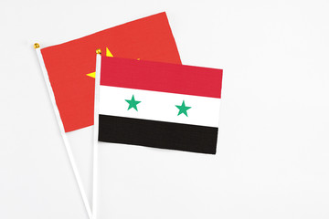 Syria and Vietnam stick flags on white background. High quality fabric, miniature national flag. Peaceful global concept.White floor for copy space.