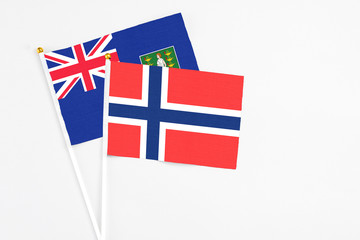 Fototapeta premium Bouvet Islands and British Virgin Islands stick flags on white background. High quality fabric, miniature national flag. Peaceful global concept.White floor for copy space.