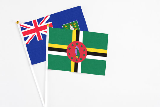 Dominica and British Virgin Islands stick flags on white background. High quality fabric, miniature national flag. Peaceful global concept.White floor for copy space.