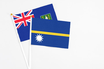 Fototapeta premium Nauru and British Virgin Islands stick flags on white background. High quality fabric, miniature national flag. Peaceful global concept.White floor for copy space.