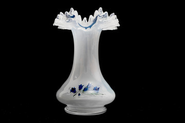 Close-up vase  milk glass with cornflowers on a black background