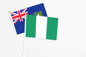 Nigeria and British Virgin Islands stick flags on white background. High quality fabric, miniature national flag. Peaceful global concept.White floor for copy space.