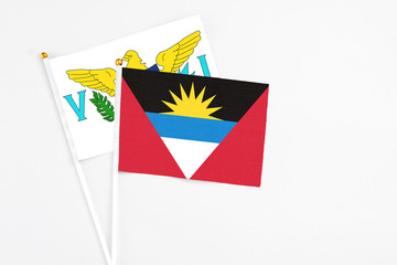 Antigua and Barbuda and United States Virgin Islands stick flags on white background. High quality fabric, miniature national flag. Peaceful global concept.White floor for copy space.