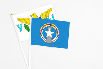 Northern Mariana Islands and United States Virgin Islands stick flags on white background. High quality fabric, miniature national flag. Peaceful global concept.White floor for copy space.