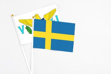 Sweden and United States Virgin Islands stick flags on white background. High quality fabric, miniature national flag. Peaceful global concept.White floor for copy space.