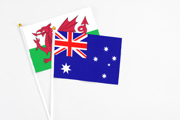 Fototapeta premium Australia and Wales stick flags on white background. High quality fabric, miniature national flag. Peaceful global concept.White floor for copy space.