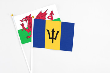 Barbados and Wales stick flags on white background. High quality fabric, miniature national flag. Peaceful global concept.White floor for copy space.