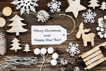 One White Label With English Text Merry Christmas And Happy New Year. Frame Of Christmas Decoration Like Tree, Sled, Star And Fir Cone. Wooden Background