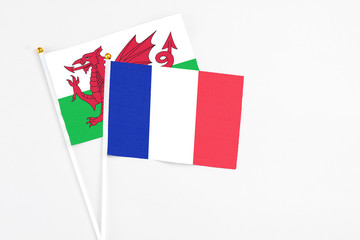 France and Wales stick flags on white background. High quality fabric, miniature national flag. Peaceful global concept.White floor for copy space.