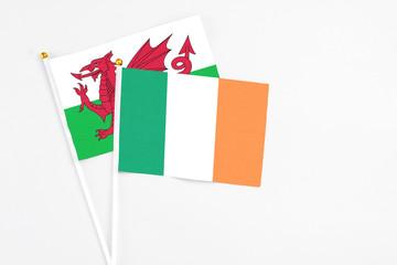 Ireland and Wales stick flags on white background. High quality fabric, miniature national flag. Peaceful global concept.White floor for copy space.