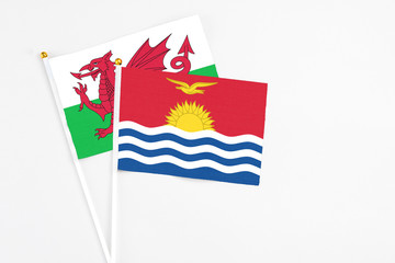 Kiribati and Wales stick flags on white background. High quality fabric, miniature national flag. Peaceful global concept.White floor for copy space.
