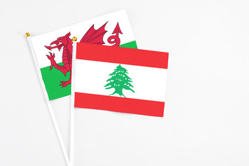 Lebanon and Wales stick flags on white background. High quality fabric, miniature national flag. Peaceful global concept.White floor for copy space.