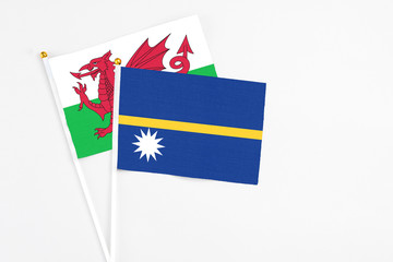 Nauru and Wales stick flags on white background. High quality fabric, miniature national flag. Peaceful global concept.White floor for copy space.