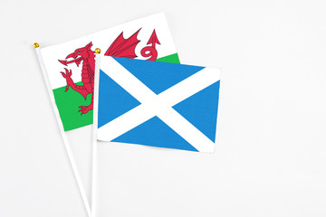 Scotland and Wales stick flags on white background. High quality fabric, miniature national flag. Peaceful global concept.White floor for copy space.