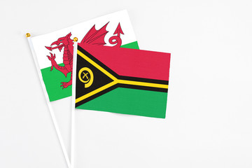 Vanuatu and Wales stick flags on white background. High quality fabric, miniature national flag. Peaceful global concept.White floor for copy space.