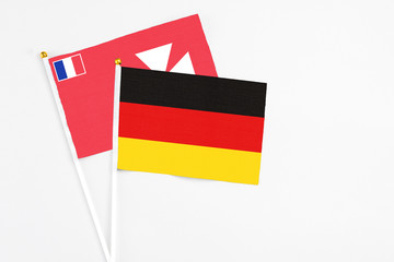 Germany and Wallis And Futuna stick flags on white background. High quality fabric, miniature national flag. Peaceful global concept.White floor for copy space.