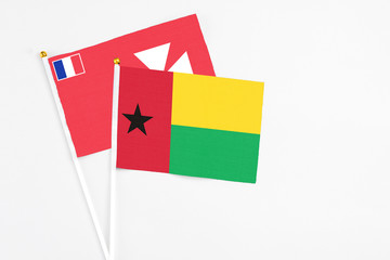 Guinea Bissau and Wallis And Futuna stick flags on white background. High quality fabric, miniature national flag. Peaceful global concept.White floor for copy space.