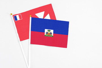 Haiti and Wallis And Futuna stick flags on white background. High quality fabric, miniature national flag. Peaceful global concept.White floor for copy space.