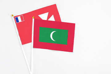 Maldives and Wallis And Futuna stick flags on white background. High quality fabric, miniature national flag. Peaceful global concept.White floor for copy space.