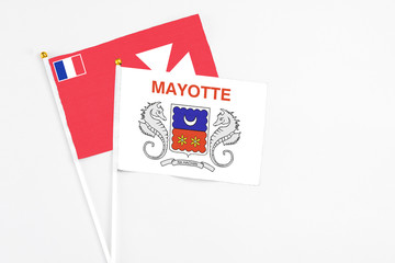 Mayotte and Wallis And Futuna stick flags on white background. High quality fabric, miniature national flag. Peaceful global concept.White floor for copy space.