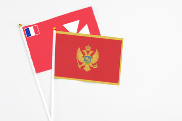 Montenegro and Wallis And Futuna stick flags on white background. High quality fabric, miniature national flag. Peaceful global concept.White floor for copy space.