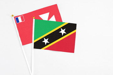 Saint Kitts And Nevis and Wallis And Futuna stick flags on white background. High quality fabric, miniature national flag. Peaceful global concept.White floor for copy space.