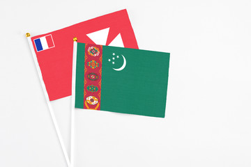 Turkmenistan and Wallis And Futuna stick flags on white background. High quality fabric, miniature national flag. Peaceful global concept.White floor for copy space.