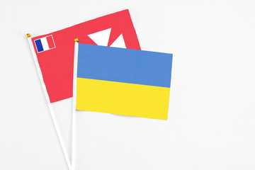 Ukraine and Wallis And Futuna stick flags on white background. High quality fabric, miniature national flag. Peaceful global concept.White floor for copy space.