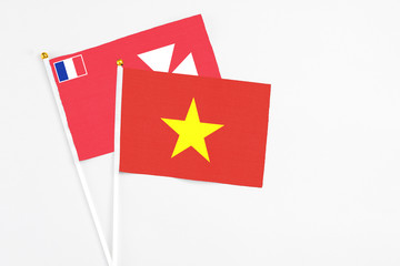 Vietnam and Wallis And Futuna stick flags on white background. High quality fabric, miniature national flag. Peaceful global concept.White floor for copy space.